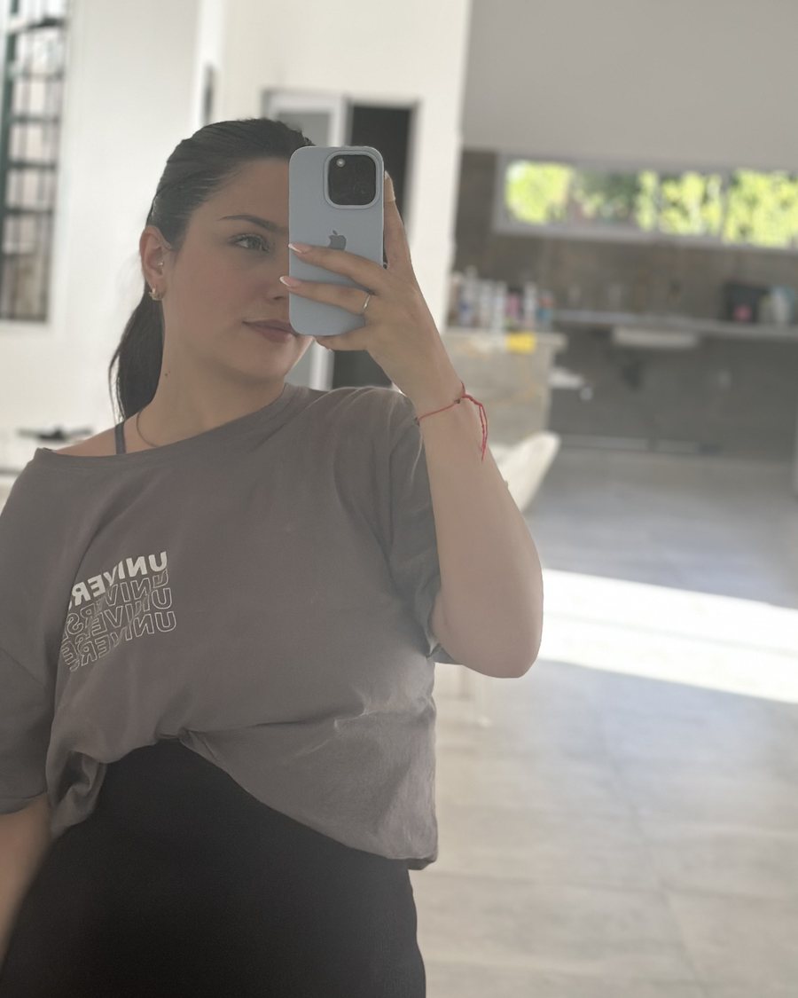 Olivia in an oversized tee in her sunlit living room